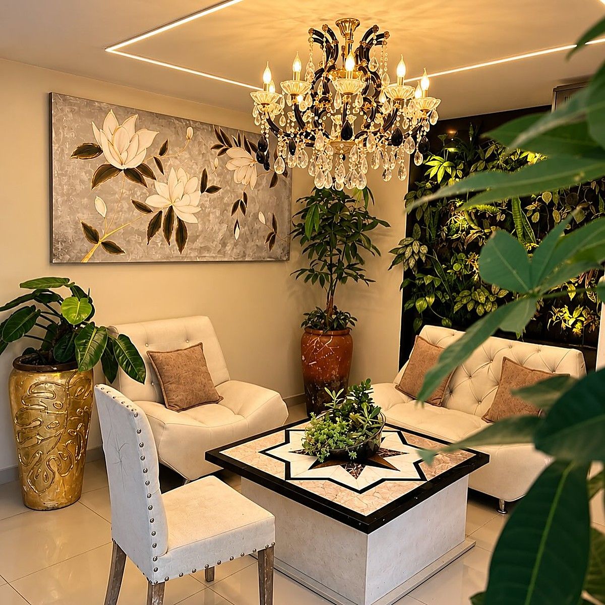 Sala de descanso de Garden SPA con sillones blancos, una lámpara de cristal y plantas